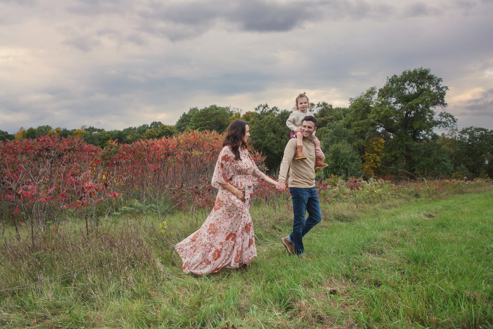 expectant mom, dad and little girl walk together