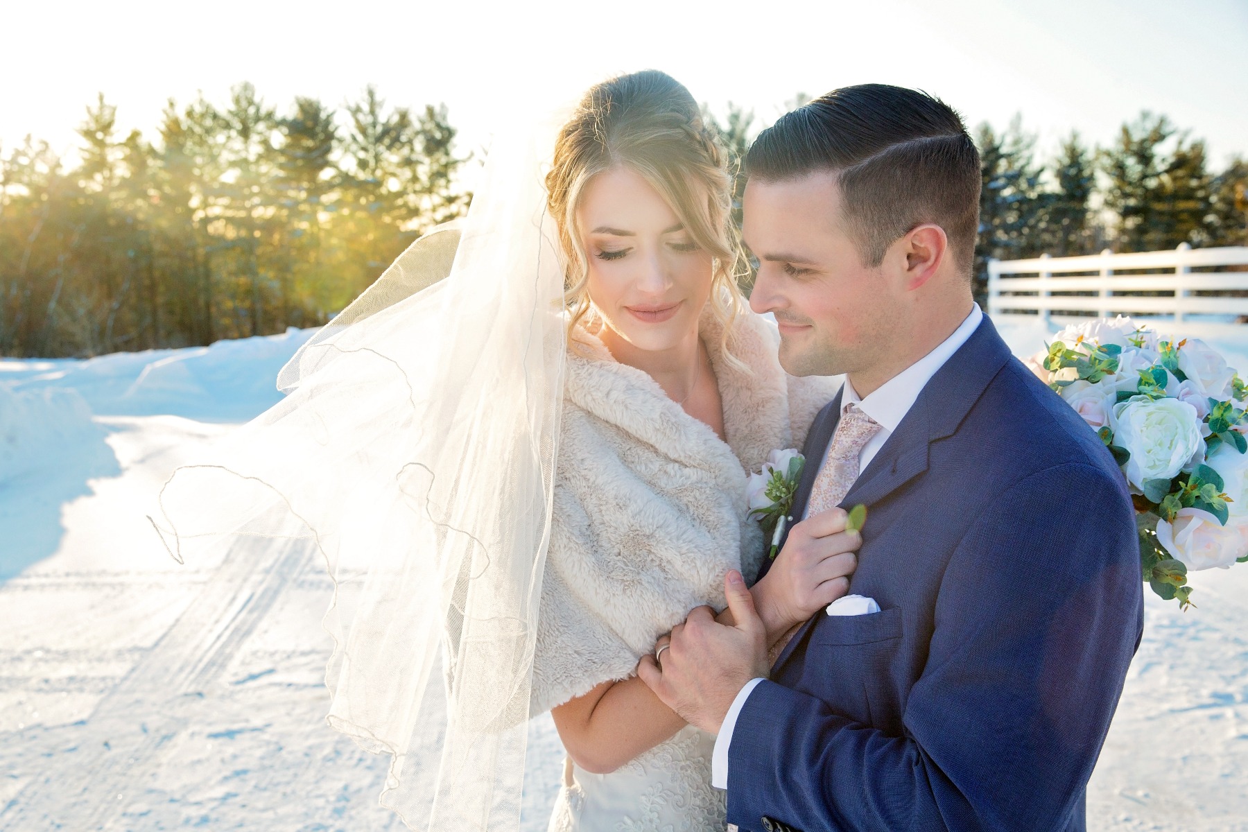 bride & groom snuggle outside on a snowy day