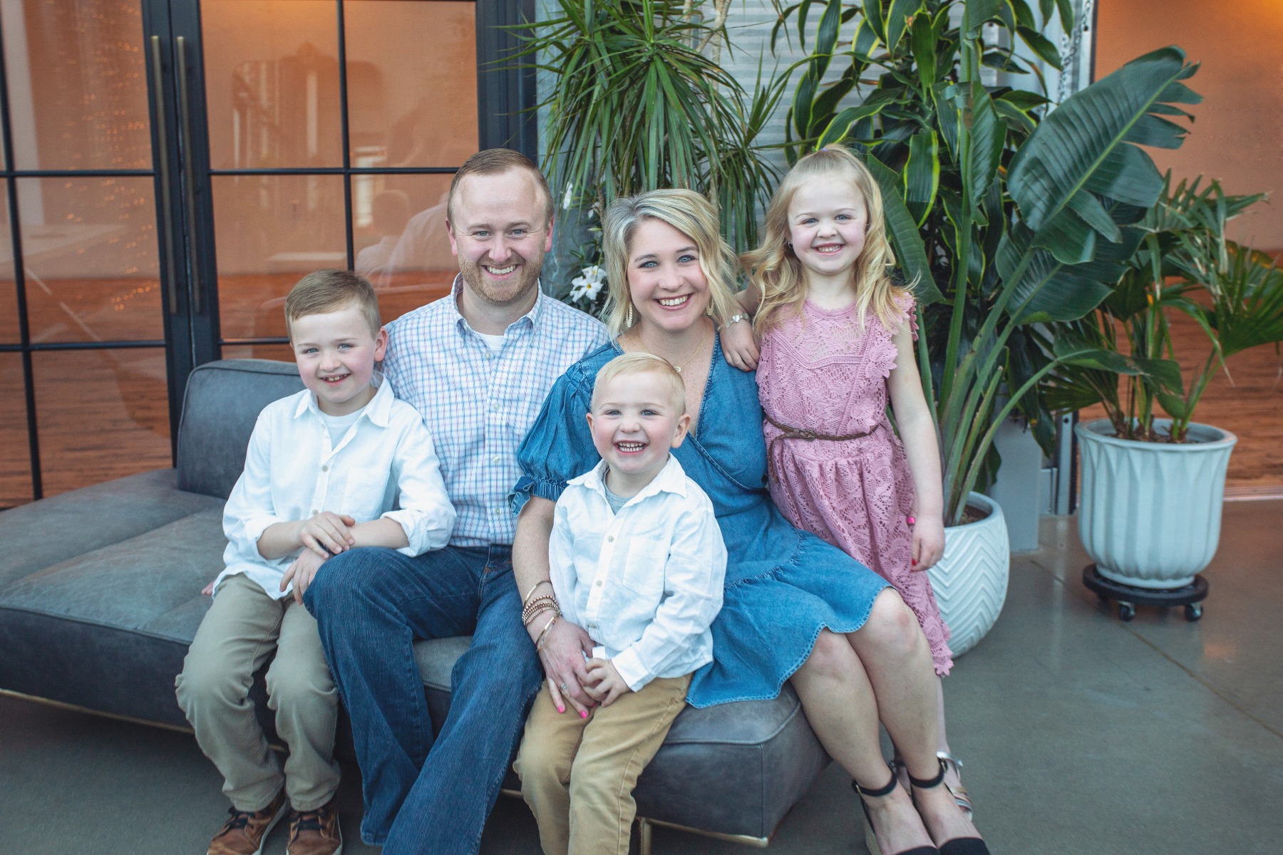 family of 5 sit together on a couch