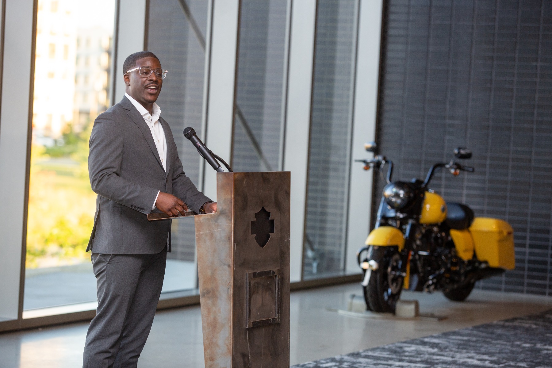 Mayor of Milwaukee speaks at a podium at Harley Davidson