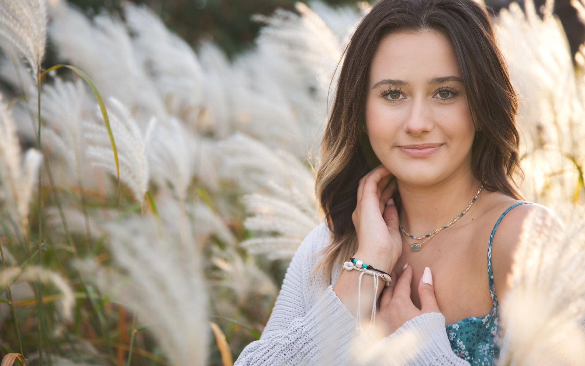 hs senior girl stands among feathery grass