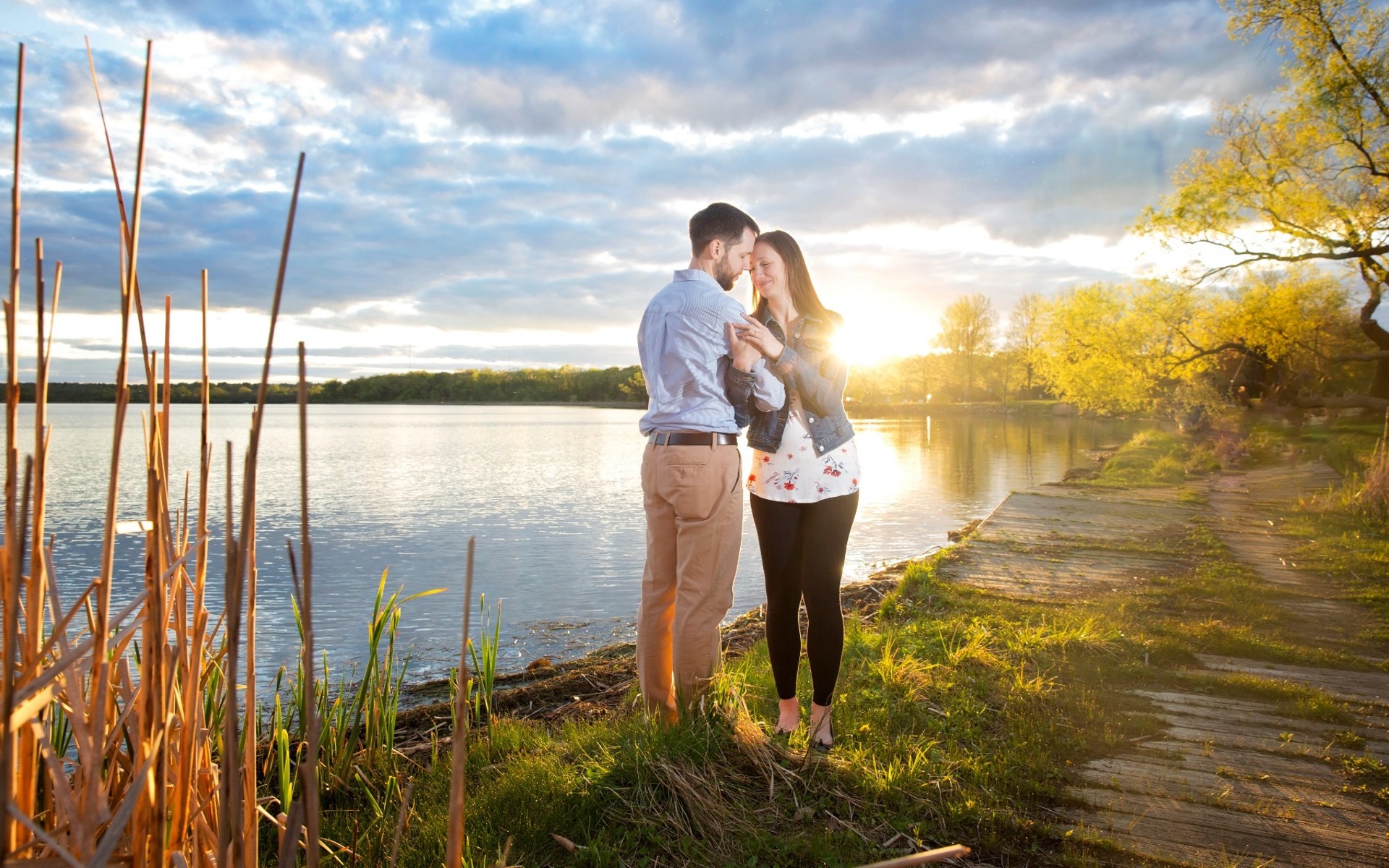 engaged couple snuggle on the shore of a madison lake