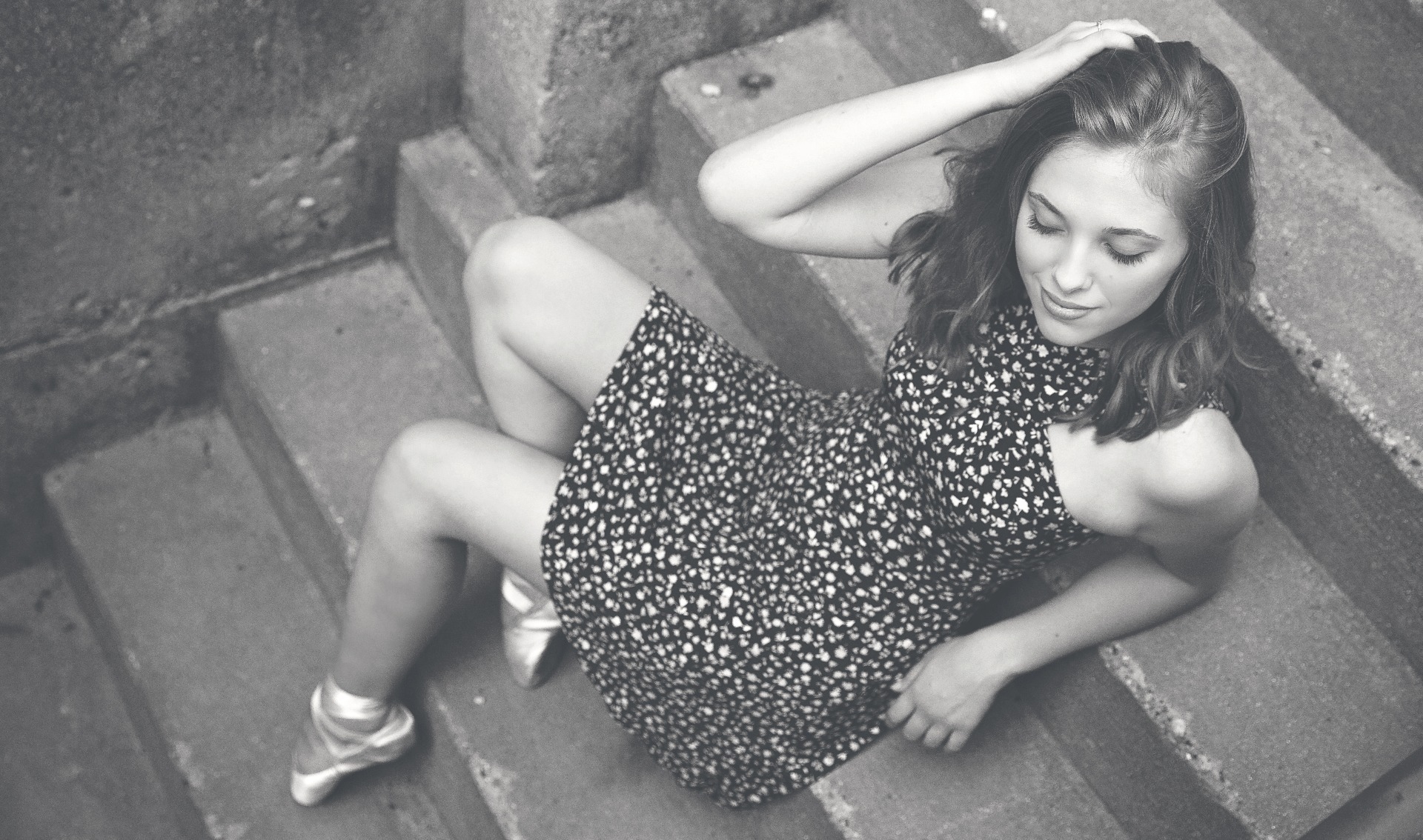 hs senior girl in ballet toe shoes poses on stairs in a b&w photo
