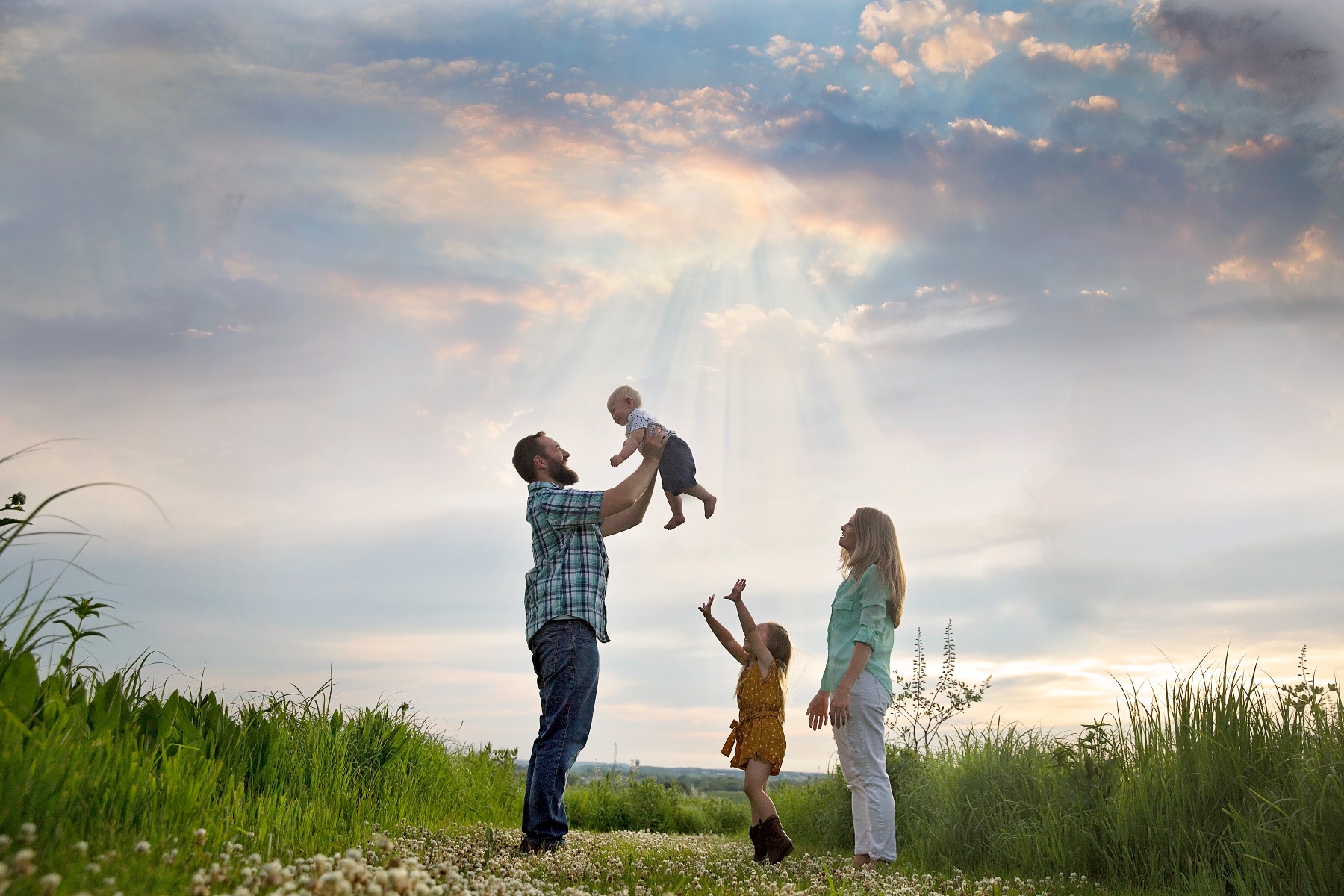 mom & daughter watch as day tosses young boy in the air
