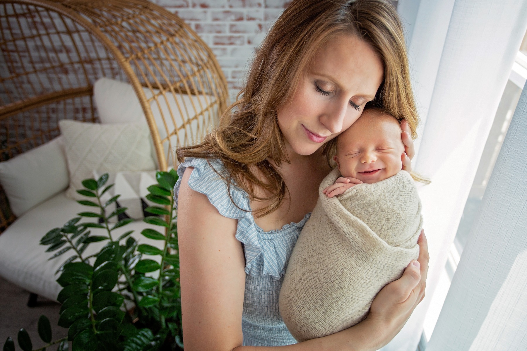 mom snuggles her sleeping newborn