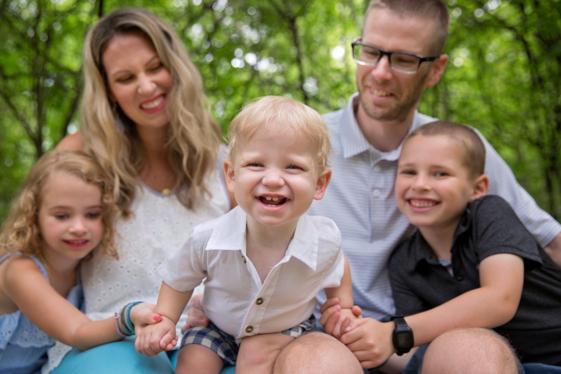 one year old laughs in leans in to the camera