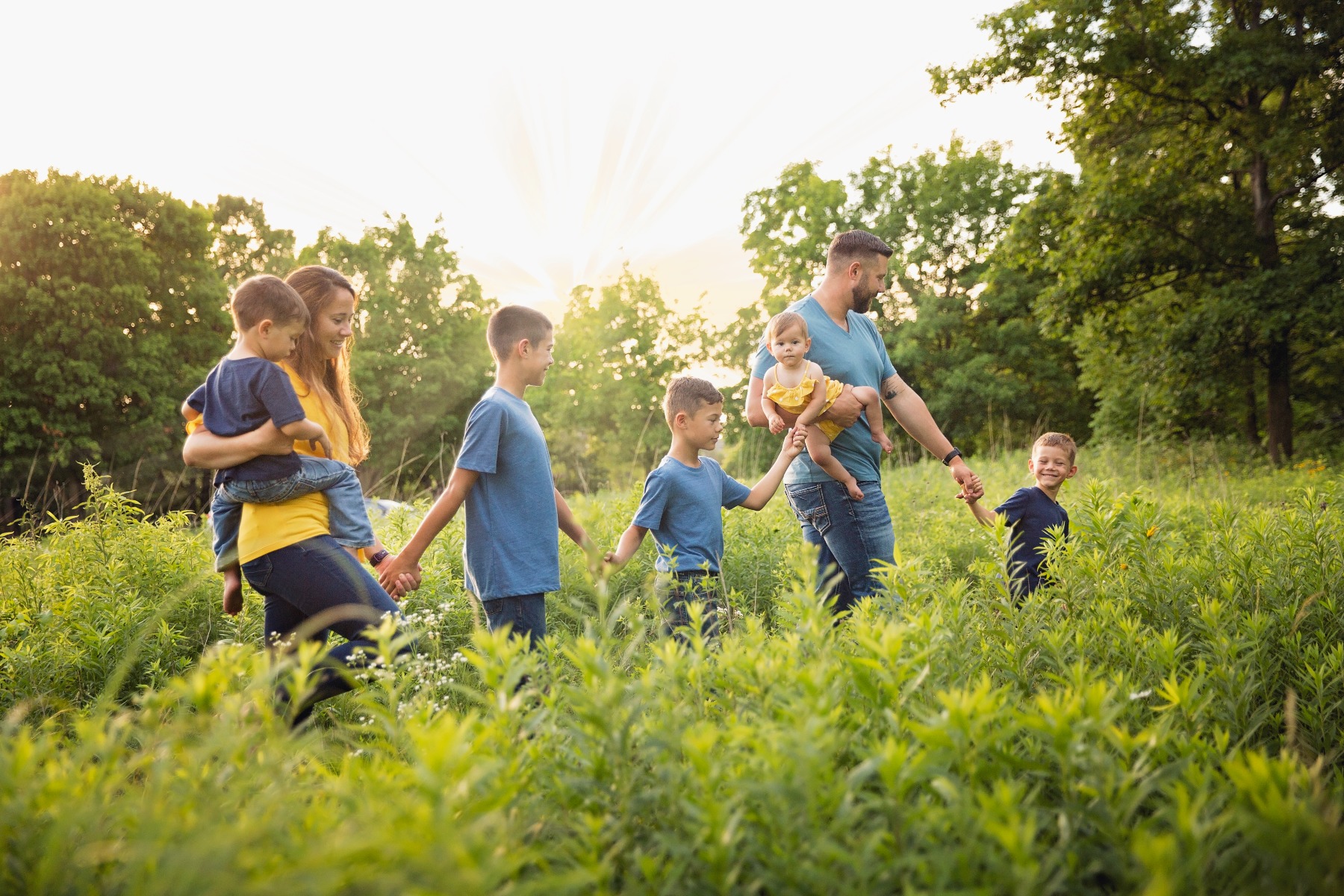 family of 7 walks across a summer field